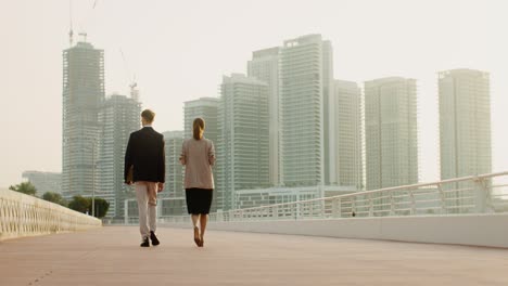 businesspeople walking on a city bridge