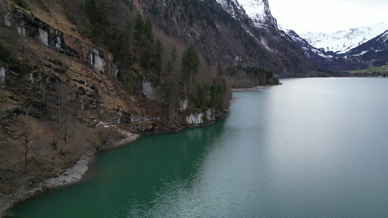 Klöntalersee, Svizzera, Glarona - ripresa aerea fluida del lago dove incontra il bordo della montagna