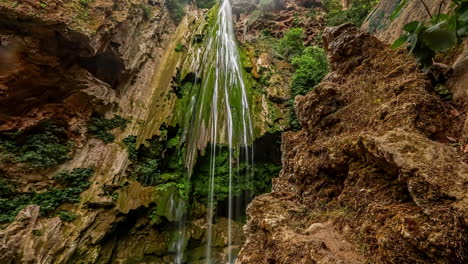 pequeña cascada en un acantilado rocoso cubierto de musgo verde