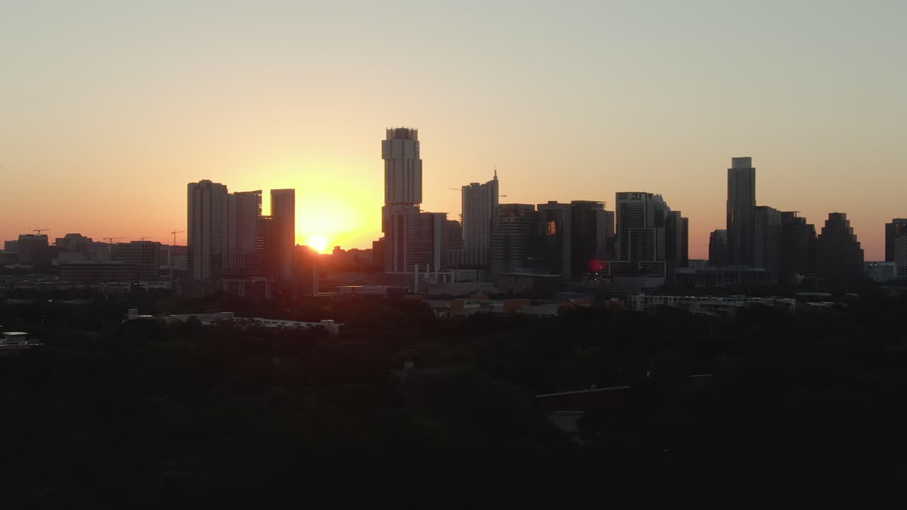 Aerial telephoto tracking shot of downtown Austin, Texas skyline at dawn on a summer day