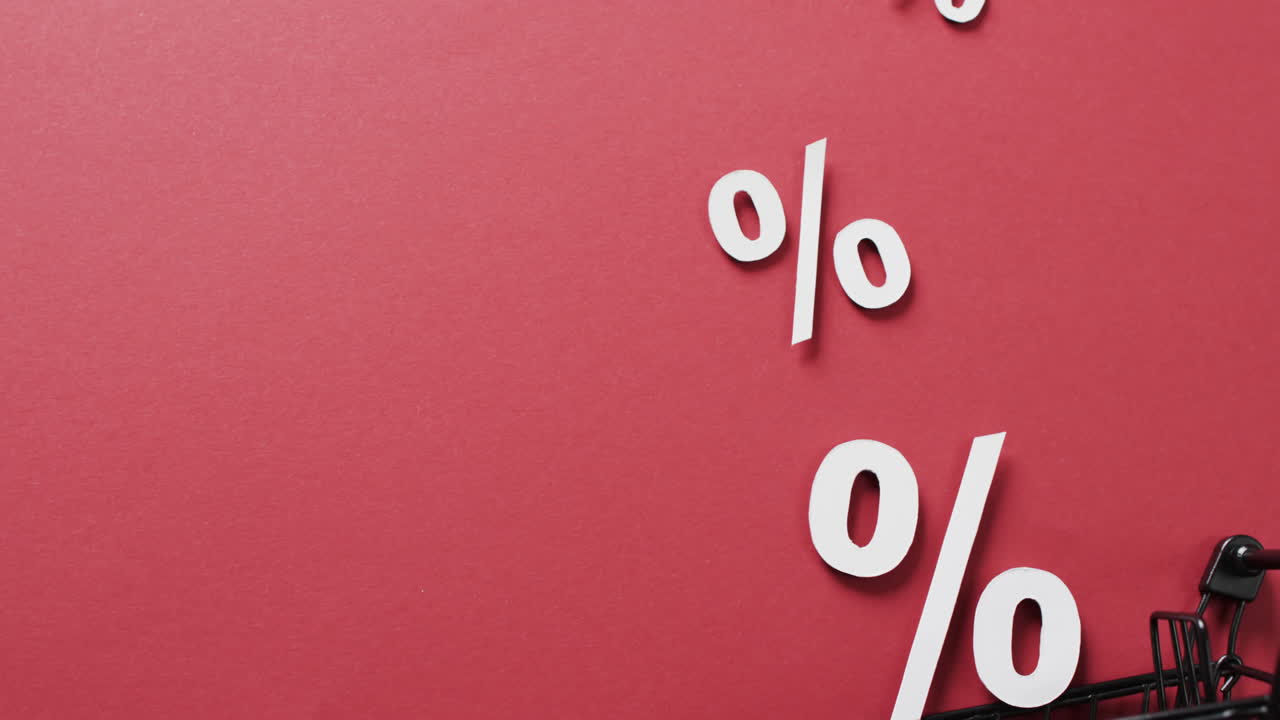 Video di carrello della spesa e segni di percentuale bianchi su sfondo rosso