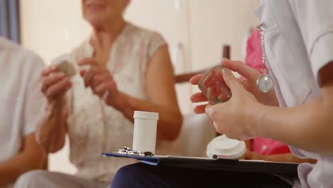 Mujer-Mayor-Con-Un-Pastillero-Hablando-Con-El-Terapeuta