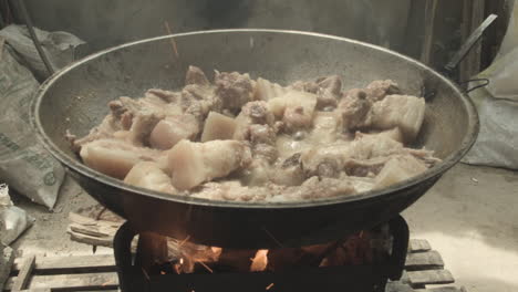 slices of pork meat being cooked in wood and coal