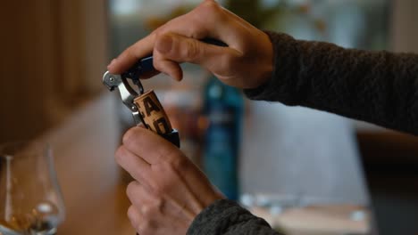person opening a wine bottle with a corkscrew in slow motion