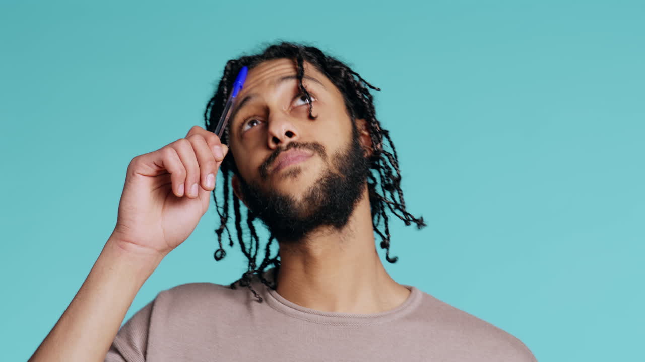 hombre pensando, tocando la pluma a la frente, viniendo con el concepto de la idea