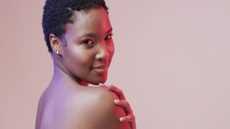mujer afroamericana con cabello oscuro corto en luz azul y rosa con espacio de copia, cámara lenta