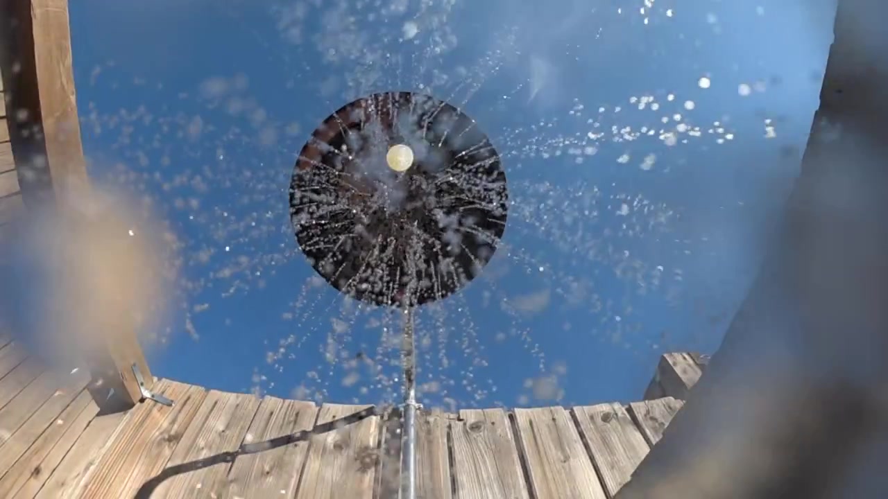 Vista astratta di acqua che schizza su uno sfondo blu con luce bokeh scintillante e numerose goccioline.