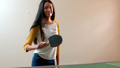 mujer jugando al tenis de mesa en casa