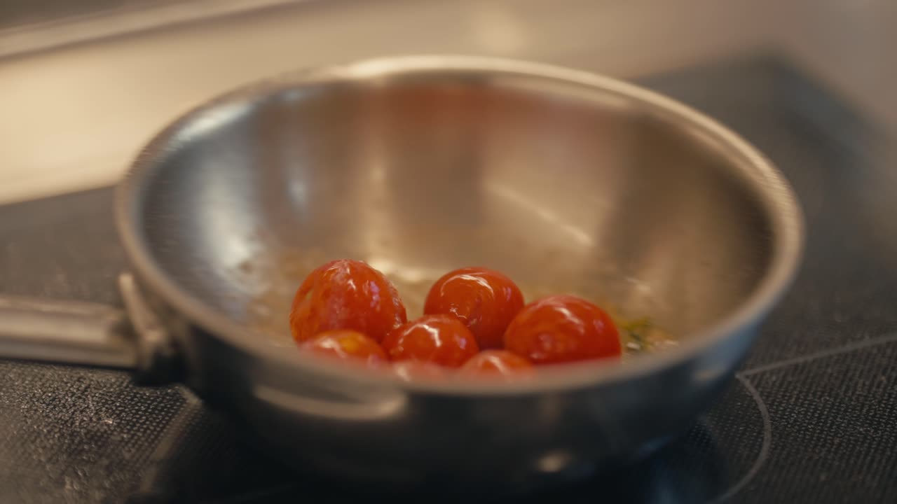 Delicious cherry tomatoes cooking in steel pan