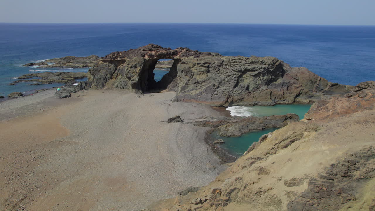 isla fuerteventura: vista aérea en un círculo sobre el arco jurado y la playa del mismo nombre en un día soleado con hermosos colores