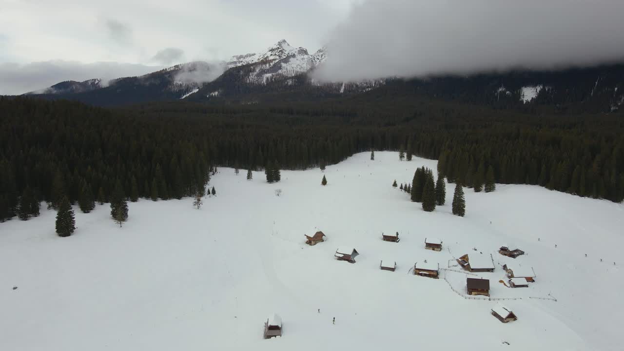 naturaleza capturada con un dron con el paisaje, montañas cubiertas de nieve a la hora dorada al amanecer con bosques y colinas circundantes capturadas en eslovenia sobre el bosque pokljuka sobre un pueblo