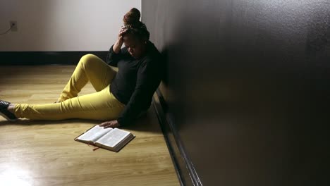 Mujer-Afroamericana-Negra-Sentada-En-El-Suelo-Leyendo-La-Biblia-Casualmente