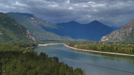 captivating aerial of fraser river near hope, bc, embraced by majestic mountain scenery