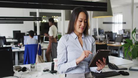 Empresaria-Asiática-Enfocada-Trabajando-En-Tableta-En-La-Oficina