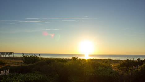 golden sun rising over calm beach at dawn