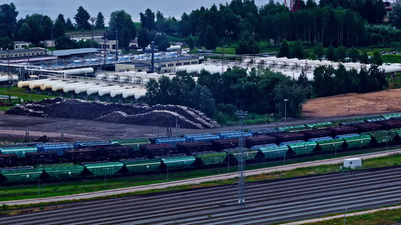 Rail Yard With A Line Of Freight Trains In The Industrial Port Of Riga, Latvia. Aerial Drone Shot