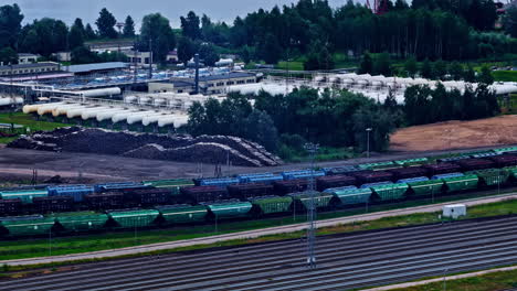 rail yard with a line of freight trains in the industrial port of riga, latvia. aerial drone shot