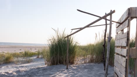 wooden refuge on the beach with a beautiful sunset behind the dune grass in langeoog island, germany. - timelapse