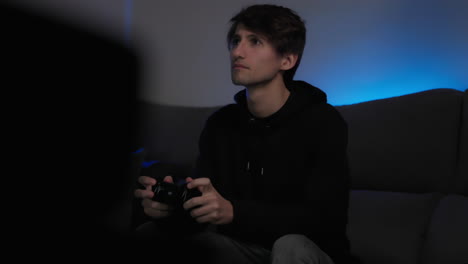 young man on couch playing video games, medium shot