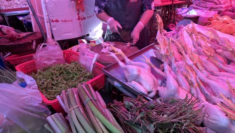 vendor arranging chickens at a busy market