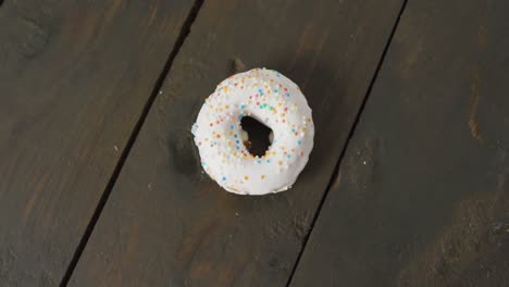 video of donut with icing on wooden background