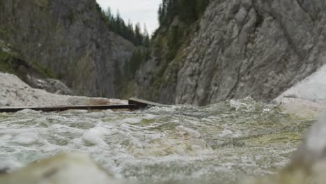 slow motion view of a creek with water running over rocks- truck shot