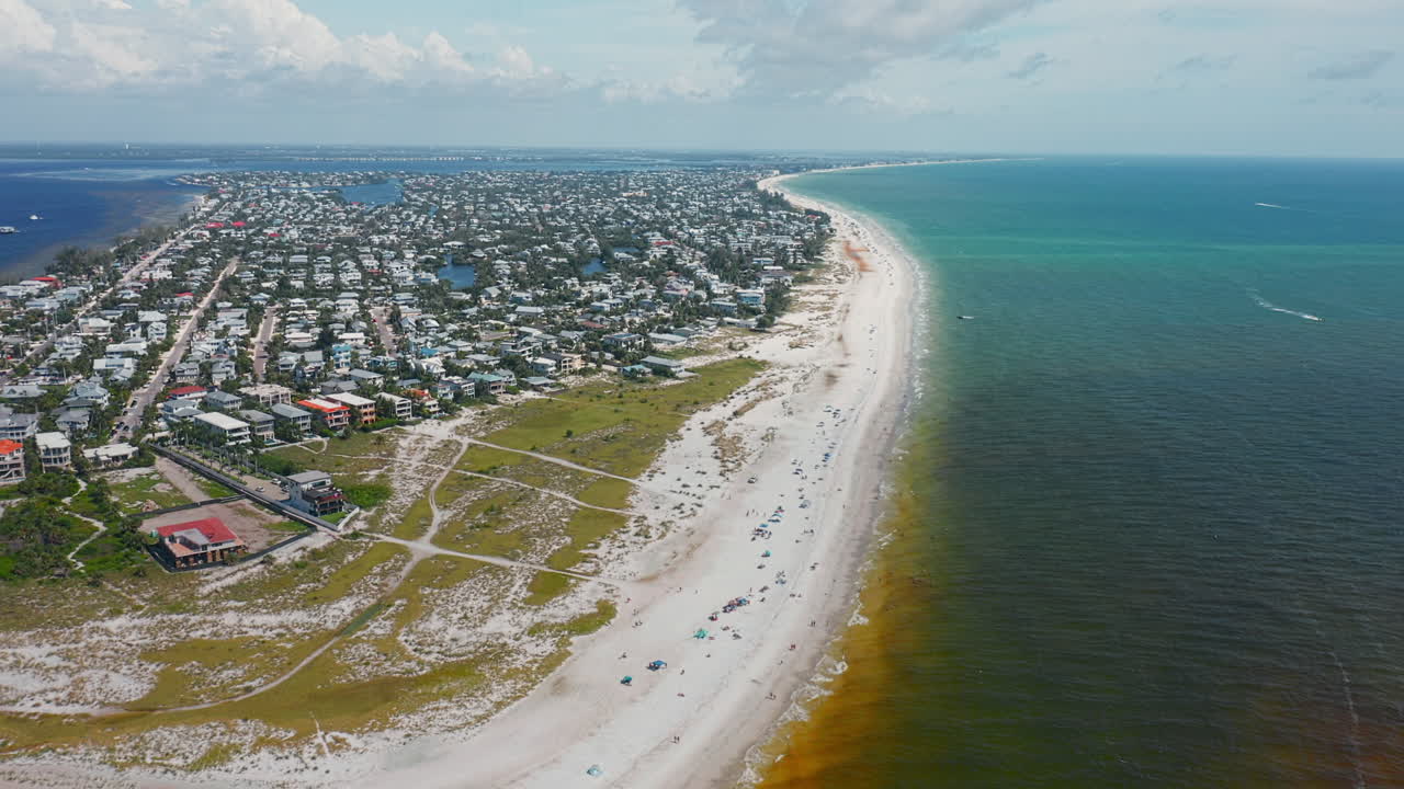 Anna Maria Island’s shoreline stretches with soft sandy beaches and turquoise waters, where rows of beachfront homes line the coast against a scenic ocean horizon