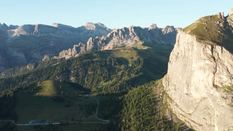 Pintoresco-Paso-De-Sella-En-Dolomitas-Durante-La-Puesta-De-Sol-Con-Cielo-Azul-Y-Cordillera-En-El-Fondo---Vista-Aérea