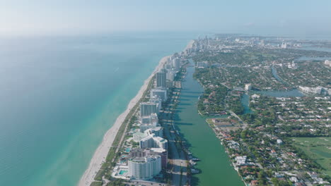 Aerial-descending-footage-of-sea-coast-in-city.-Row-tall-apartment-buildings-in-luxury-residential-borough.-Miami,-USA