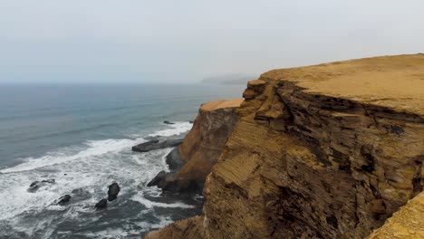 aerial shot of flying over the edge of the coast line at the paracas national park