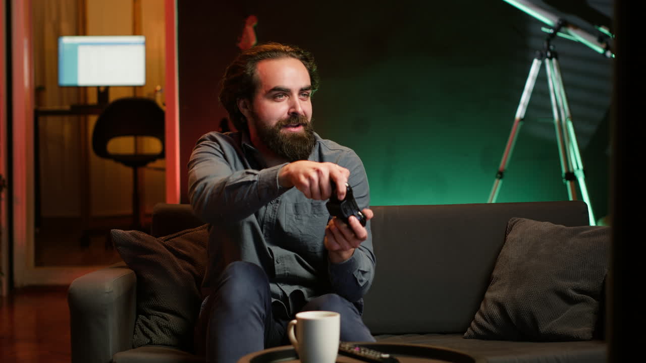 hombre feliz jugando a un videojuego en una casa iluminada con neón, sosteniendo un controlador
