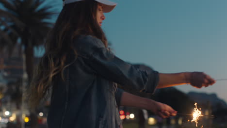 dancing teenage girl with sparklers on beach at sunset celebrating new years eve having fun independence day celebration with fireworks enjoying freedom