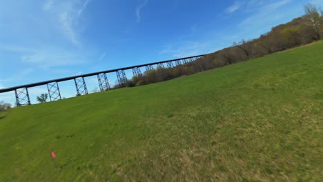 a low angle view with an fpv drone flying towards the moodna viaduct in salisbury mills, ny on a sunny day