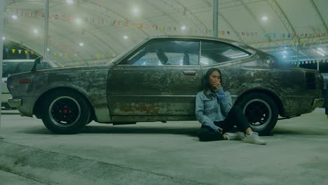 woman sitting beside vintage car at night
