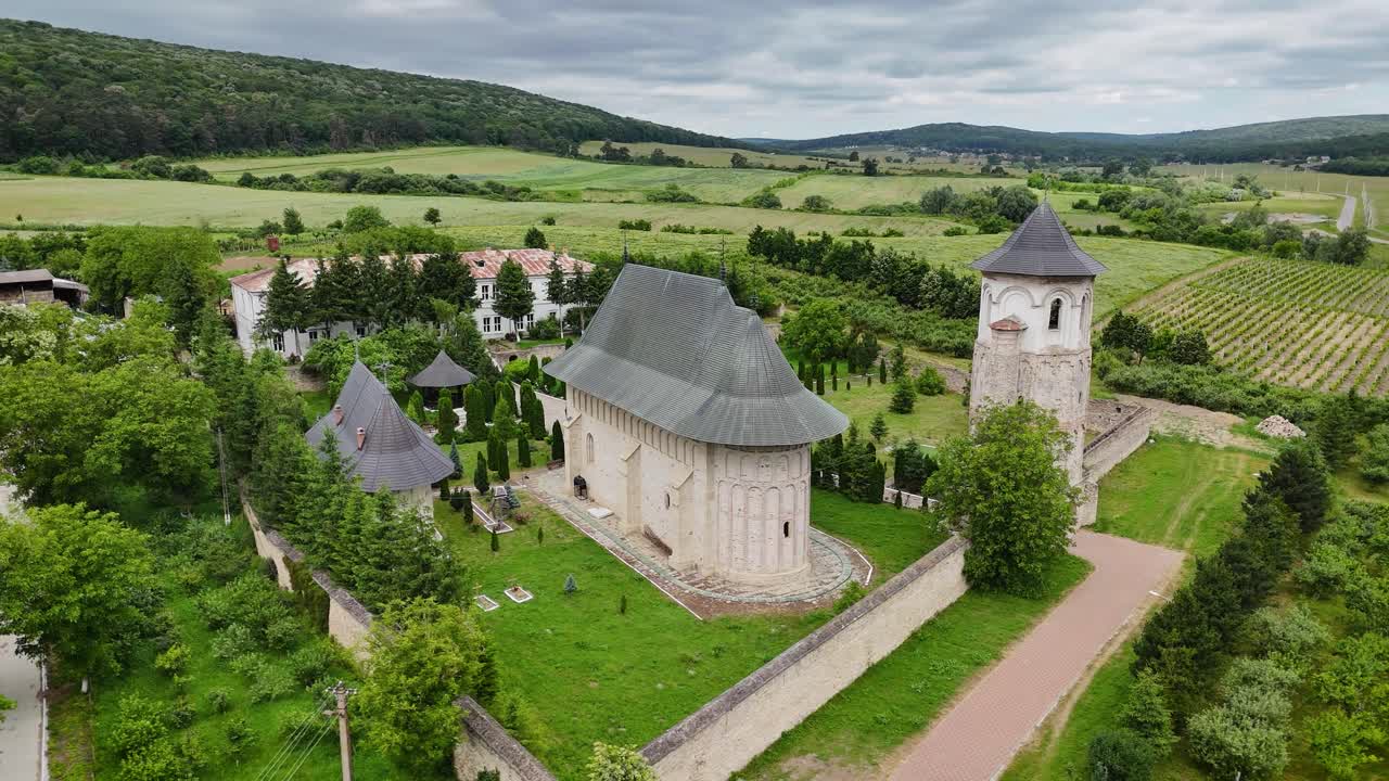 Drone video of Dobrovat Monastery in Romania, showing the church and surrounding forest from an aerial perspective