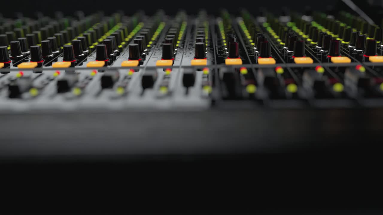 Close-up of Professional Audio Mixing Console with Flashing Lights