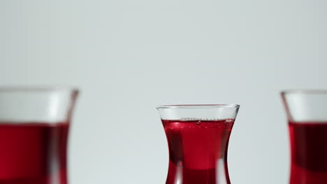 pouring red liquid from a glass carafe into a glass