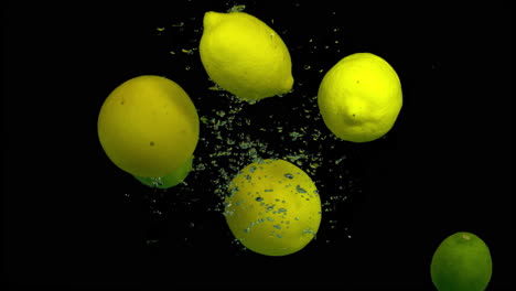 lemons and limes splashing underwater