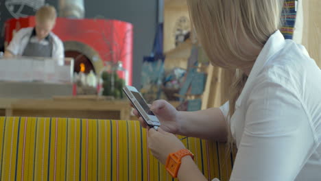 Woman-with-smart-phone-in-pizzeria-restaurant