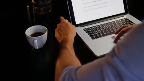 Mid-section-of-young-Caucasian-male-executive-working-on-laptop-at-table-in-modern-office-4k