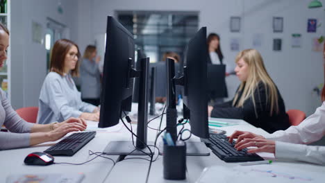 group of women working at computers in an office