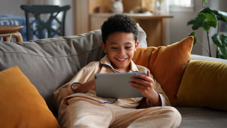 boy using tablet on couch