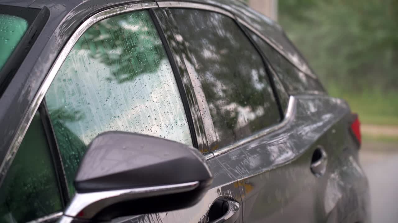 Water droplets on car windows during manual washing