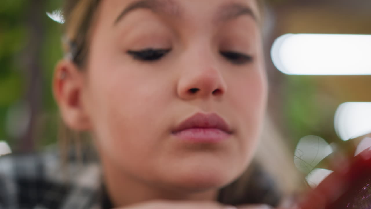 vista en primer plano de una joven mezclando maquillaje en sus ojos con enfoque en la aplicación delicada de eyeliner, logrando un aspecto suave y preciso con técnicas sutiles de mezcla de maquillaje