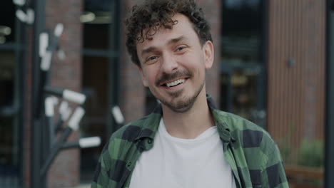smiling man in front of building
