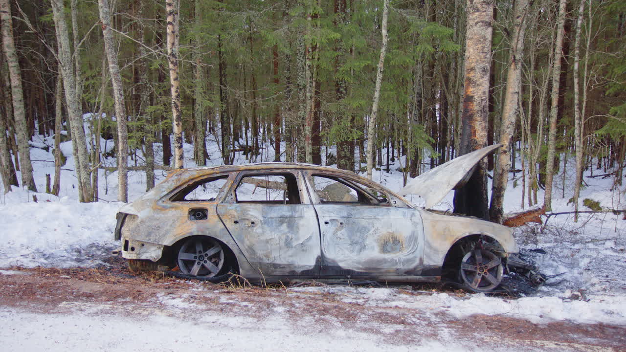 Side view approach to wrecked car that crashed after losing control on icy road
