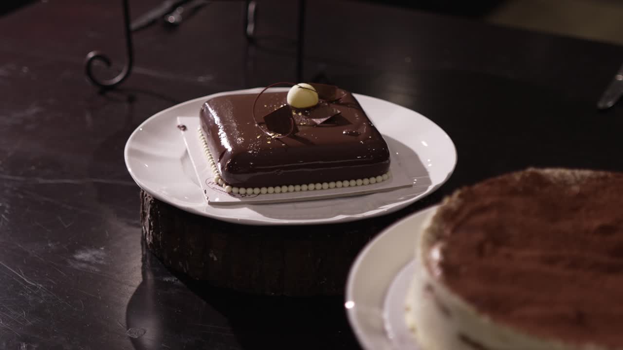 Square chocolate dessert with glossy glaze and decorations on a wedding table