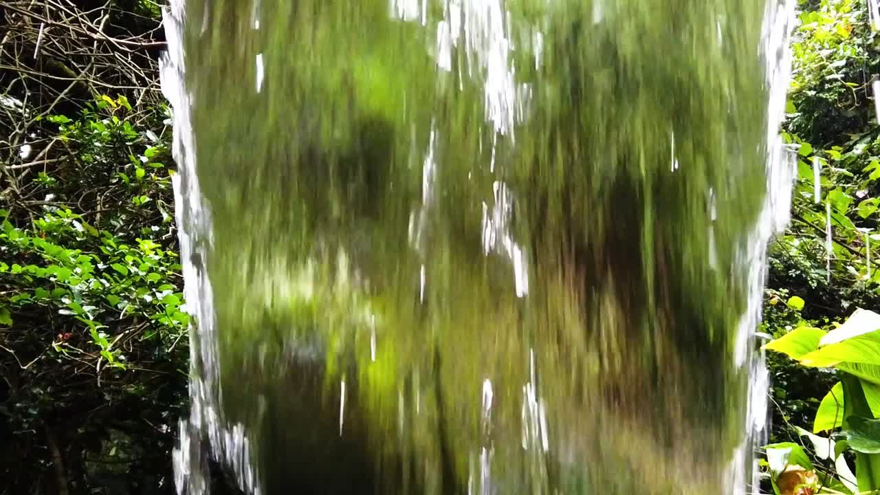 Behind a small waterfall in super slow motion