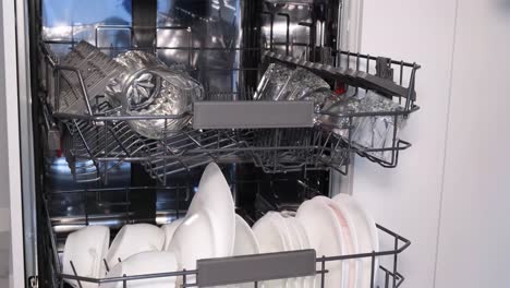 woman loading dishes into dishwasher in modern kitchen