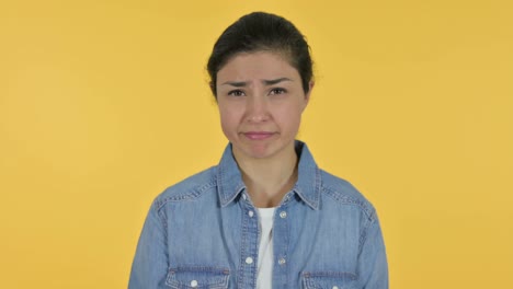 young indian woman no sign by finger, yellow background